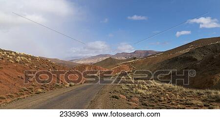 Stock Image - A paved road through a landscape of hills and mountains. Fotosearch