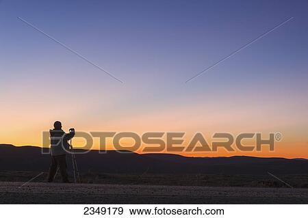 A photographer is silhoutted against the sunset above Eagle Summit along the Steese Highway; Fairbanks, Alaska, United States of America View Large Photo Image Stock Photo - A photographer is silhoutted against the sunset above Eagle Summit along the Steese Highway; Fairbanks, Alaska, United States of America. Fotosearch