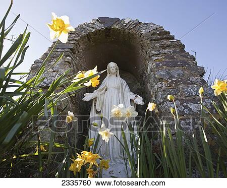 A religious statue inside an arch stone structure and daffodils growing outside View Large Photo Image Stock Image - A religious statue inside an arch stone structure and daffodils growing outside. Fotosearch