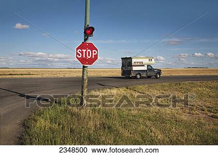 Stock Image - A stop sign and red light at an intersection; Saskatchewan, Canada. Fotosearch
