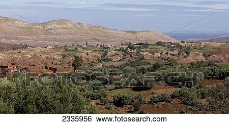 Stock Photograph - A town in a valley with a view of mountains in the distance. Fotosearch