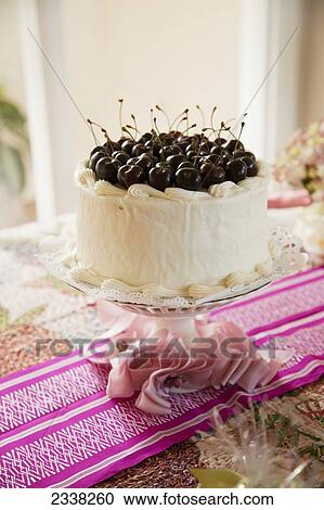 A white iced cake topped with fresh cherries on a pink table runner; California, United States of America View Large Photo Image Stock Image - A white iced cake topped with fresh cherries on a pink table runner; California, United States of America. Fotosearch