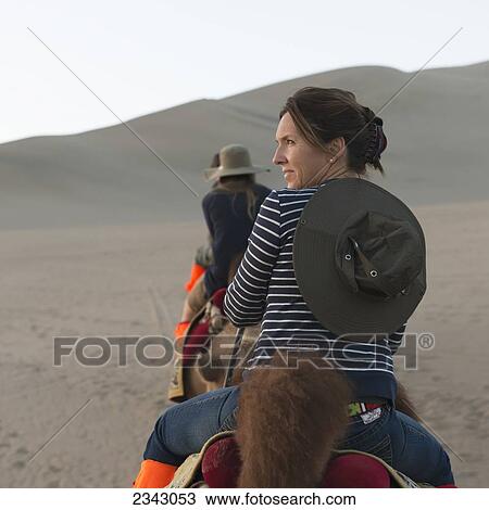 A woman and her daughters riding camels on a desert landscape; Jiuquan, Gansu, China View Large Photo Image Stock Image - A woman and her daughters riding camels on a desert landscape; Jiuquan, Gansu, China. Fotosearch