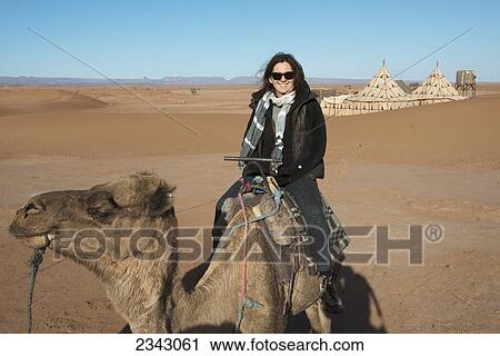 A woman riding a camel on the Erg Chegaga Dunes; Souss-Massa-Draa, Morocco View Large Photo Image Stock Image - A woman riding a camel on the Erg Chegaga Dunes; Souss-Massa-Draa, Morocco. Fotosearch