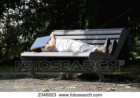 A woman sleeping on a park bench with a book over her face; Locarno, Ticino, Switzerland View Large Photo Image Stock Image - A woman sleeping on a park bench with a book over her face; Locarno, Ticino, Switzerland. Fotosearch