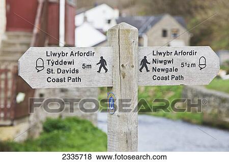 Stock Photo - A wooden sign and post for walking paths; Wales. Fotosearch