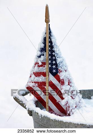 Stock Image - An American flag covered in snow; United States of America. Fotosearch