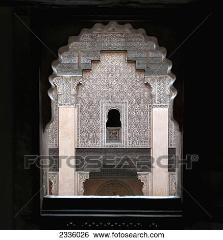 Stock Photograph - An arched window with a view of a wall with ornate facade. Fotosearch