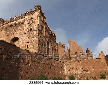 Picture - An old wall and building under a blue sky. Fotosearch