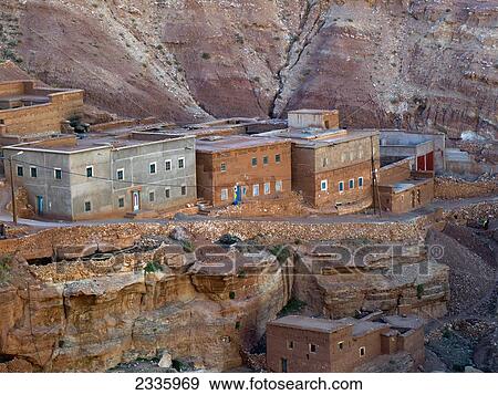 Stock Photo - Buildings and a road at the base of a mountain. Fotosearch