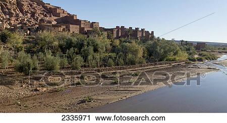 Buildings built at the base of a rugged hillside at the water's edge View Large Photo Image Stock Image - Buildings built at the base of a rugged hillside at the water's edge . Fotosearch