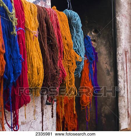 Bundles of various colours of yarn hanging against a wall View Large Photo Image Stock Image - Bundles of various colours of yarn hanging against a wall. Fotosearch