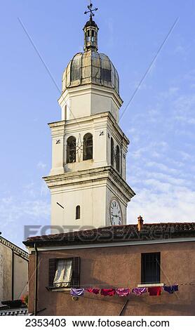 Stock Image - Clock tower on a church and laundry hanging to dry on a clothesline outside a house; Venice, Italy. Fotosearch