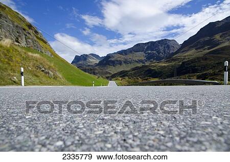 Close up of a paved road with a view of the mountains in the distance View Large Photo Image Stock Photo - Close up of a paved road with a view of the mountains in the distance. Fotosearch