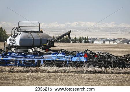 Close up of air seeder in field with snow covered mountains and blue sky in background; Airdrie, Alberta, Canada View Large Photo Image Stock Photography - Close up of air seeder in field with snow covered mountains and blue sky in background; Airdrie, Alberta, Canada. Fotosearch