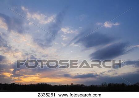 Glowing sky over the silhouette of a forest at sunset; Ohio, United States of America View Large Photo Image Stock Image - Glowing sky over the silhouette of a forest at sunset; Ohio, United States of America. Fotosearch
