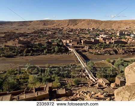 Stock Image - High angle view of buildings in a remote town and a road bridge crossing a river. Fotosearch