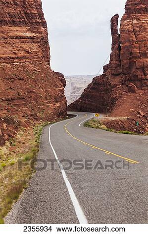 Highway 95 west of Hite, Utah as the road drops down between two red sandstone formations to the Colorado River; Utah, United States of America View Large Photo Image Picture - Highway 95 west of Hite, Utah as the road drops down between two red sandstone formations to the Colorado River; Utah, United States of America. Fotosearch