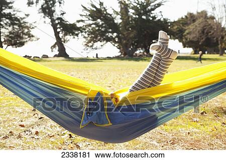Stock Image - Legs of a young girl sticking up out of a hammock; Crab Cove, California, United States of America. Fotosearch