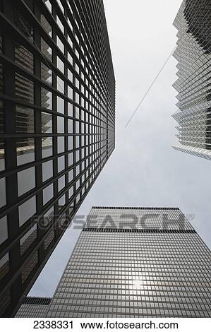 Stock Image - Low angle view of skyscrapers towering and framing blue sky and clouds; Toronto, Ontario, Canada. Fotosearch