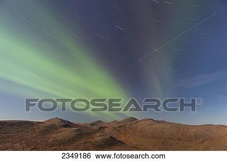 Stock Photograph - Northern Lights above Eagle Summit and Pinelle Mountain Range along the Steese Highway, North of Fairbanks; Alaska, United States of America. Fotosearch