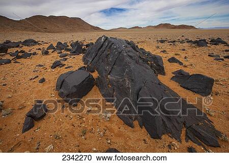 Stock Image - Pitch black rocks in the desert; Klein-Aus Vista, Namibia. Fotosearch