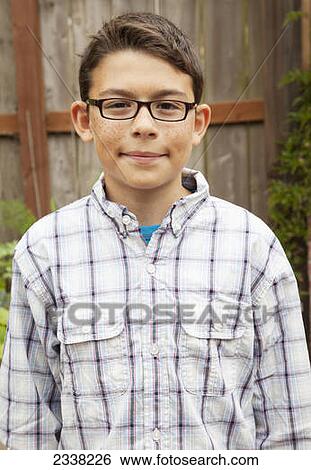 Stock Photograph - Portrait of a boy with freckles and eyeglasses; Pacifica, California, United States of America. Fotosearch