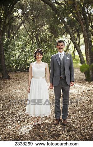 Portrait of a couple standing in a park in formalwear; California, United States of America View Large Photo Image Stock Photo - Portrait of a couple standing in a park in formalwear; California, United States of America. Fotosearch