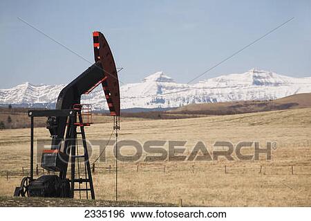 Pumpjack in a field with snow covered mountains and blue sky; Longview, Alberta, Canada View Large Photo Image Stock Photograph - Pumpjack in a field with snow covered mountains and blue sky; Longview, Alberta, Canada. Fotosearch