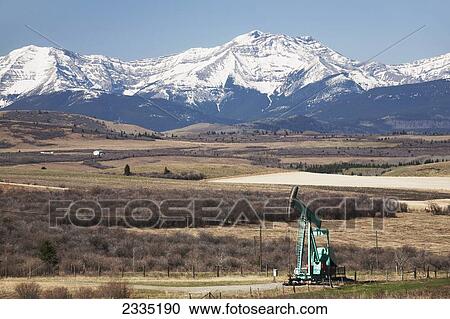 Pumpjack in the foothills with snow covered mountains and blue sky; Longview, Alberta, Canada View Large Photo Image Stock Image - Pumpjack in the foothills with snow covered mountains and blue sky; Longview, Alberta, Canada. Fotosearch