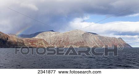 Stock Photo - Rainbow over Labrador coastal mountains; Newfoundland and Labrador, Canada. Fotosearch