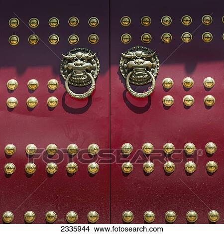Red doors with round gold decorative pieces and door knockers in animal likeness View Large Photo Image Picture - Red doors with round gold decorative pieces and door knockers in animal likeness. Fotosearch