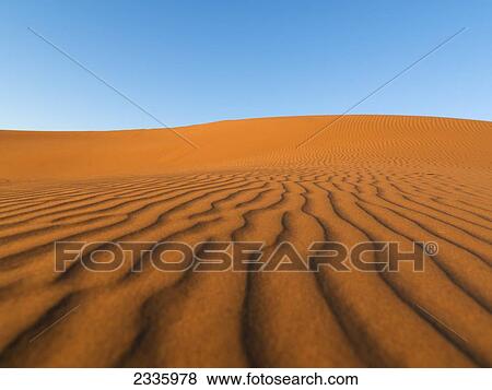 Stock Photo - Ridges in the sand and a blue sky. Fotosearch