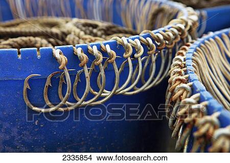 Picture - Rusted hooks tied onto a blue edge. Fotosearch