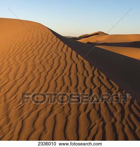 Sand slopes and ridges with a blue sky View Large Photo Image Stock Image - Sand slopes and ridges with a blue sky. Fotosearch