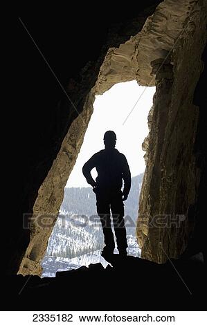 Silhouette of male hiker in cave with entrance glowing in the background; Bragg Creek, Alberta, Canada View Large Photo Image Stock Image - Silhouette of male hiker in cave with entrance glowing in the background; Bragg Creek, Alberta, Canada. Fotosearch