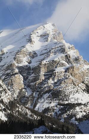 Snow covered mountain with blue sky and cloud; Kananaskis Country, Alberta, Canada View Large Photo Image Stock Image - Snow covered mountain with blue sky and cloud; Kananaskis Country, Alberta, Canada. Fotosearch