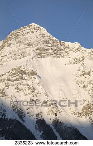 Snow covered mountain with blue sky; Kananaskis Country, Alberta, Canada View Large Photo Image Stock Image - Snow covered mountain with blue sky; Kananaskis Country, Alberta, Canada. Fotosearch