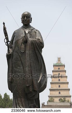 Statue of buddha with a tiered tower in the background View Large Photo Image Stock Photograph - Statue of buddha with a tiered tower in the background. Fotosearch