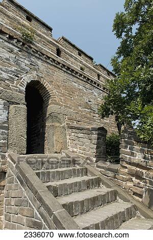 Stock Image - Steps up to an arched doorway in a stone wall. Fotosearch