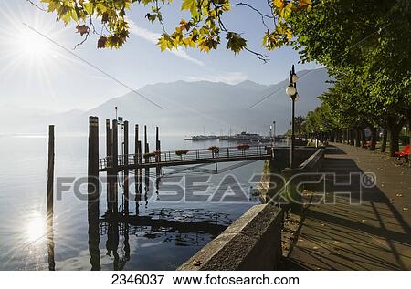 Stock Photo - Sunlight reflecting on Lake Maggiore beside the promenade; Locarno, Ticino, Switzerland. Fotosearch