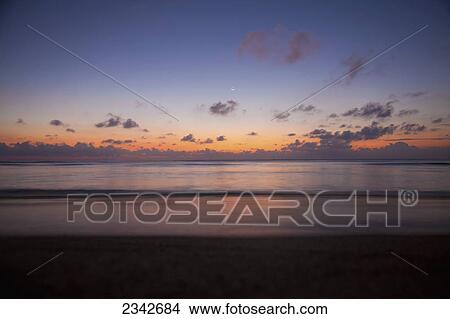 Sunset on the horizon from a beach; Oahu, Hawaii, United States of America View Large Photo Image Picture - Sunset on the horizon from a beach; Oahu, Hawaii, United States of America. Fotosearch