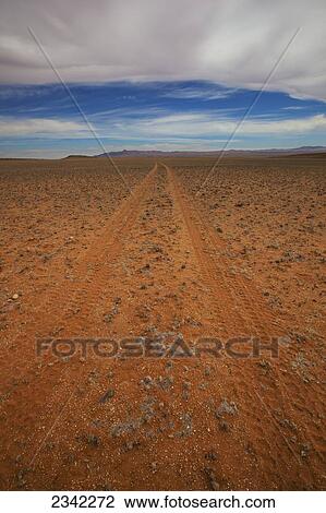 Stock Image - Tire tracks in the dirt on a desert landscape; Klein-Aus Vista, Namibia. Fotosearch