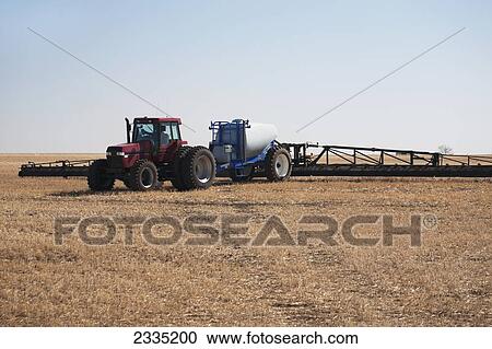 Tractor with sprayer in field with blue sky; Alberta, Canada View Large Photo Image Stock Image - Tractor with sprayer in field with blue sky; Alberta, Canada. Fotosearch