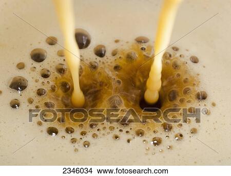 Two streams of milk being poured into frothy coffee; Locarno, Ticino, Switzerland View Large Photo Image Picture - Two streams of milk being poured into frothy coffee; Locarno, Ticino, Switzerland. Fotosearch