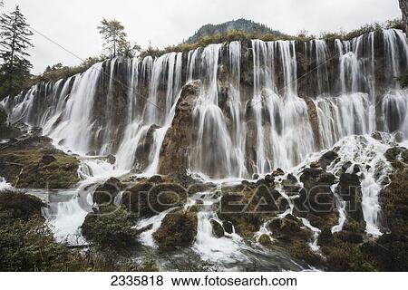 Waterfalls over a cliff and streaming over rocks View Large Photo Image Stock Photo - Waterfalls over a cliff and streaming over rocks. Fotosearch
