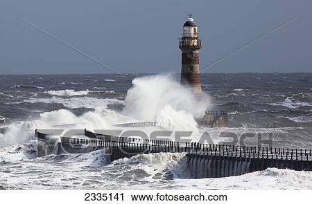 Waves crashing into a lighthouse on the coast; Sunderland, Tyne and Wear, England View Large Photo Image Stock Image - Waves crashing into a lighthouse on the coast; Sunderland, Tyne and Wear, England. Fotosearch