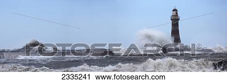 Stock Image - Waves crashing into a lighthouse; Sunderland, Tyne and Wear, England. Fotosearch