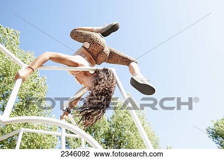 Woman playing on jungle gym, climbing it and spinning over the bars; California, United States of America View Large Photo Image Stock Image - Woman playing on jungle gym, climbing it and spinning over the bars; California, United States of America. Fotosearch