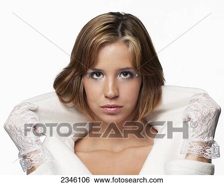 Young woman posed in the studio popping the collar of a white jacket with lacey gloves against a white backdrop; California, United States of America View Large Photo Image Stock Photograph - Young woman posed in the studio popping the collar of a white jacket with lacey gloves against a white backdrop; California, United States of America. Fotosearch
